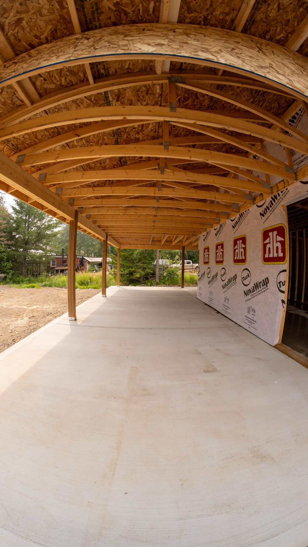 Covered timber breezeway with curved roof trusses on a new lakeside build